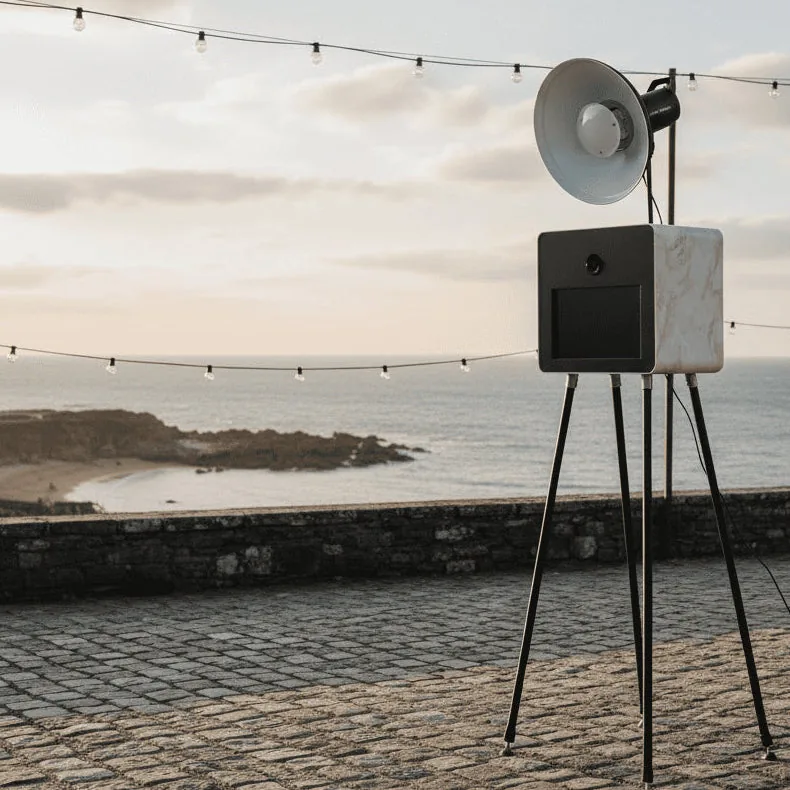 Photobooth effet marbre sur une terrasse pavée face à la mer